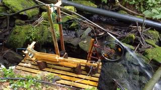 Water-powered saw beside a stream